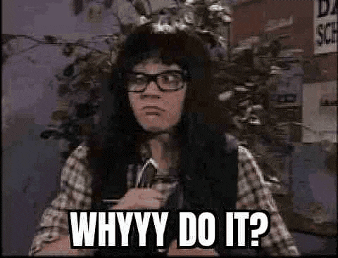 a man wearing glasses and a plaid shirt is holding a microphone and asking why do it ?