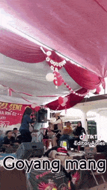 a group of people are standing in front of a stage and a sign that says goyang mang
