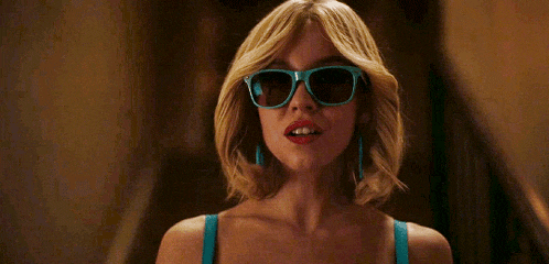a woman wearing sunglasses and a blue bra is standing next to a staircase .