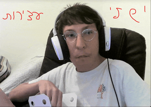 a man wearing headphones is sitting in front of a wall that says ' i 's e '