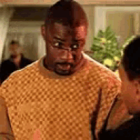 a man wearing glasses and a sweater is standing in front of a woman .