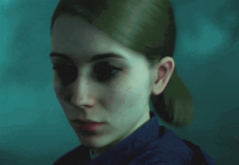 a close up of a woman 's face in a dark room