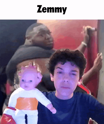 a boy holding a doll with the name zemmy on the top