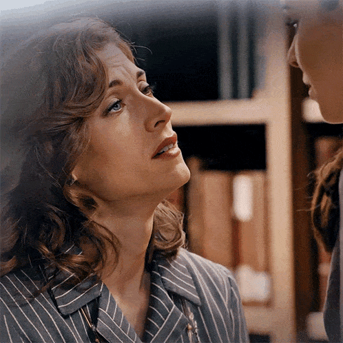 a woman in a striped shirt is looking up at something