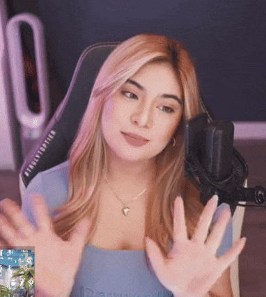 a woman is sitting in a chair in front of a microphone with her hands outstretched