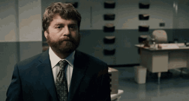 a man in a suit and tie is standing in an office