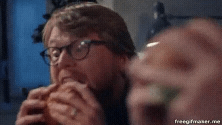 a man wearing glasses is eating a sandwich with a freegifmaker.me watermark on the bottom