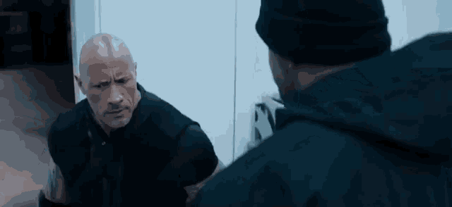two men are standing next to each other in a room .