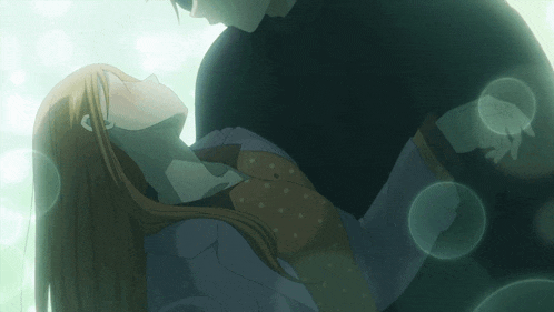 a man is holding a woman in his arms with bubbles in the background