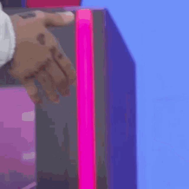 a man and a woman are holding hands in front of a pink light .