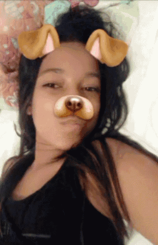 a girl wearing a dog face mask laying on a bed