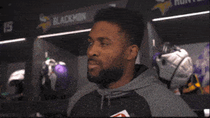 a man in a locker room with the name blackmon on the wall above him