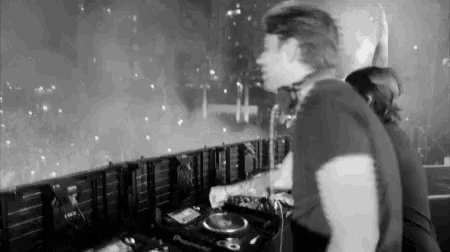 a black and white photo of a man playing a dj set