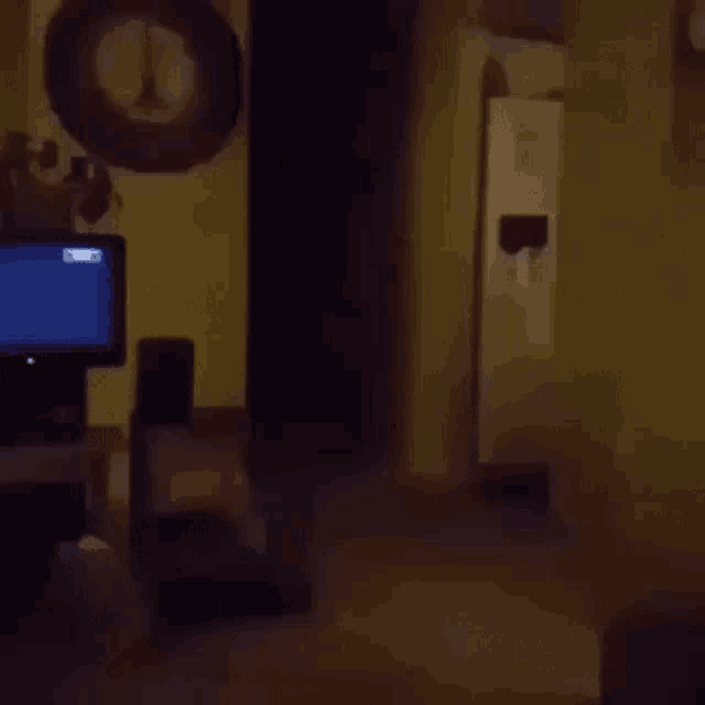 a dark living room with a television and a mirror