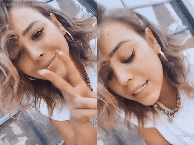 a close up of a woman giving a peace sign with her hand