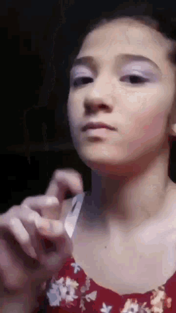 a girl in a floral dress is making a funny face