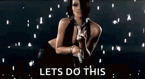 a woman in a black dress is holding a gun in her hand .