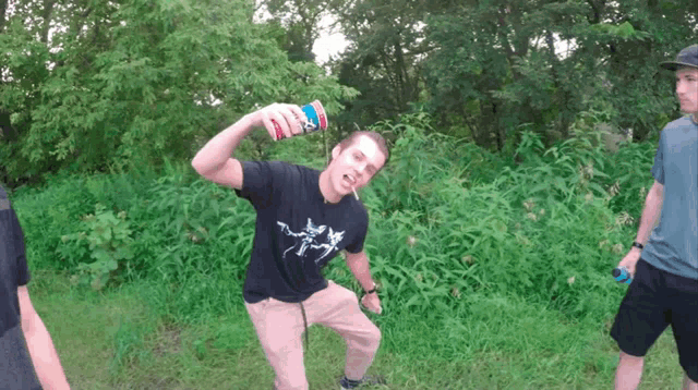 a man in a black shirt is holding a can of diet pepsi