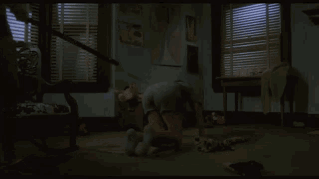 a woman in shorts is holding a stick in a room with a rocking chair