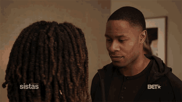 a man and a woman are looking at each other with a bet logo in the corner