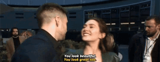a man and a woman are standing next to each other and the woman says " you look beautiful you look great too "