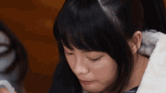 a close up of a woman 's face with her eyes closed .