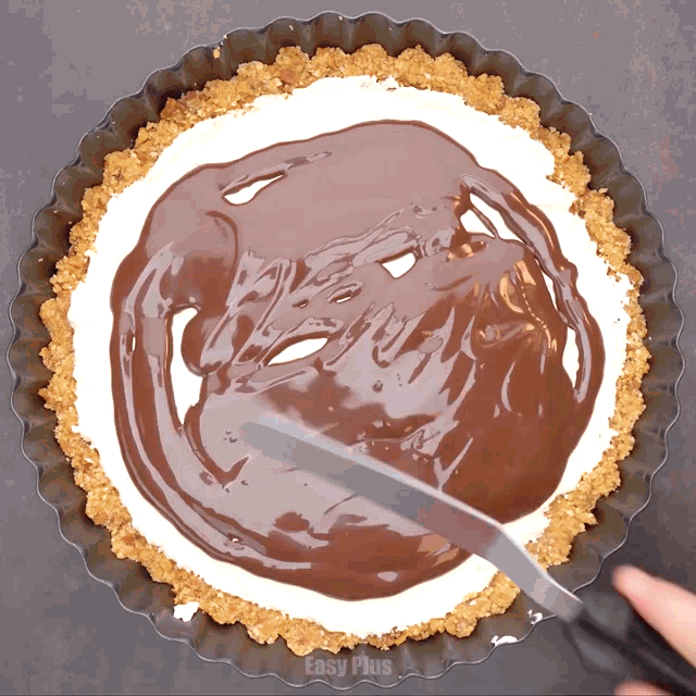 someone is spreading chocolate on top of a pie crust