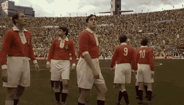 a group of soccer players are standing on a field with the number 9 and 10 on their jerseys