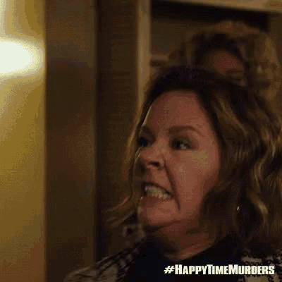 a woman is making a funny face in a room with another woman behind her .