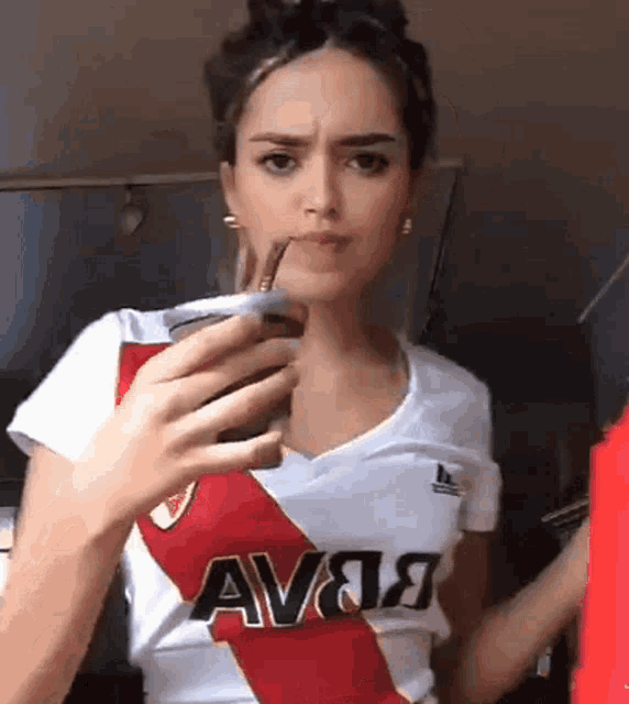 a woman wearing a white shirt with the word ava on it