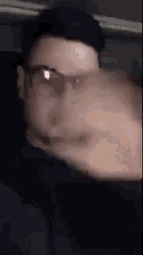a man wearing glasses is making a funny face .