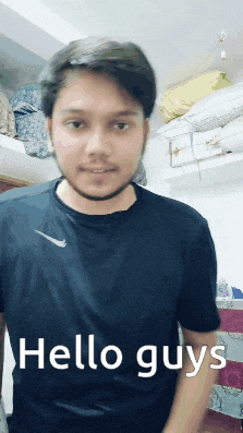 a man in a black nike shirt is standing in front of a shelf with pillows and says hello guys