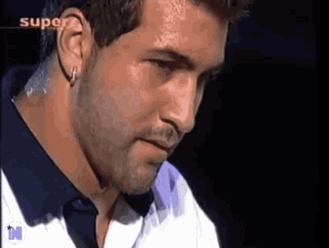 a close up of a man 's face with super written on the bottom right