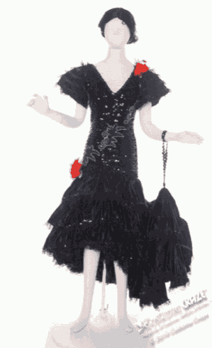 the back of a mannequin wearing a black dress with ruffles