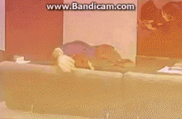 a man and a woman are sitting on a couch and the website www.bandicam.com is in the corner
