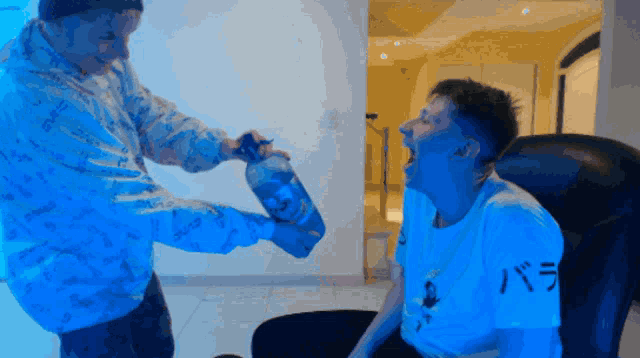 a man in a t-shirt that says ' バラ ' on it is being poured into another man 's mouth