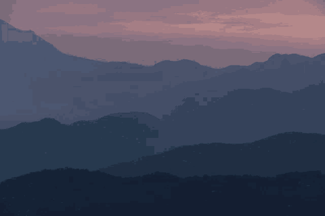 the mountains are silhouetted against a pink sky at sunset