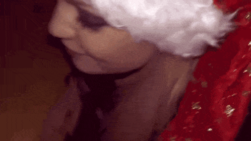 a woman wearing a santa hat and a red dress