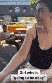 a woman sitting at a table with the words girl who is going to be okay on the bottom