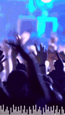 a crowd of people raising their hands in the air at a concert with a blue background