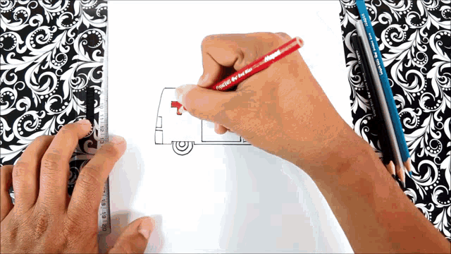a person is drawing a mail van with a red pencil