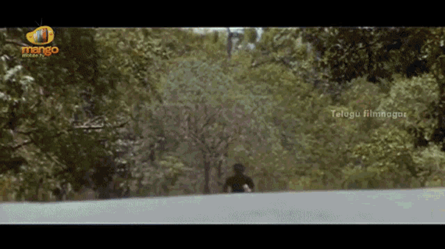a man walking down a road with telugu filmnagar on the bottom right