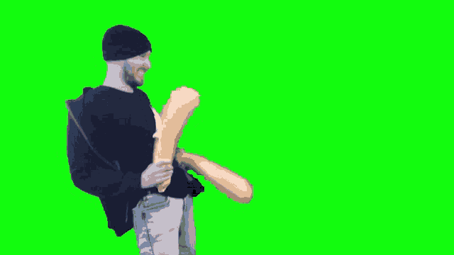 a man in a black hat is holding a large inflatable object on a green screen