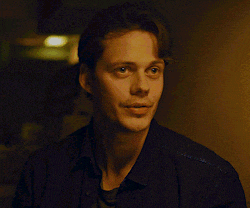 a man in a black shirt is looking at the camera