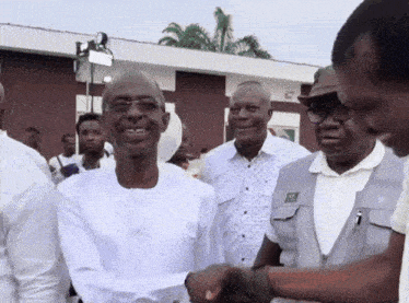 a man shaking hands with a man wearing a vest that says ns on it