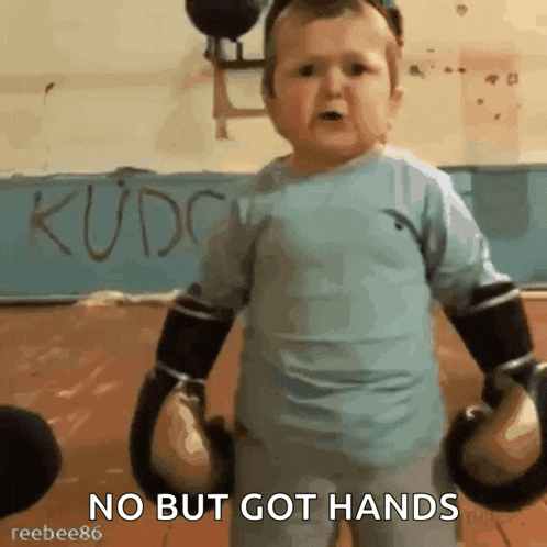 a young boy wearing boxing gloves says no but got hands