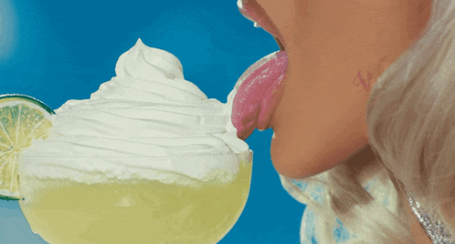 a woman licking a margarita with whipped cream