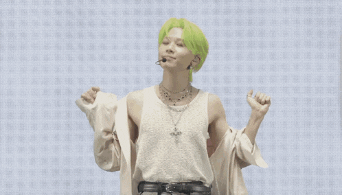 a man with green hair wears a white tank top