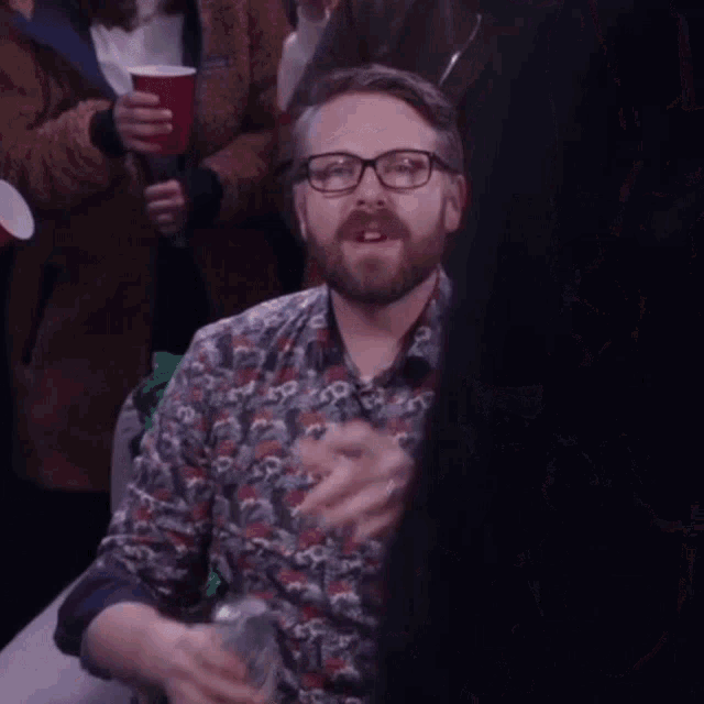 a man with glasses and a beard says everybody in blue