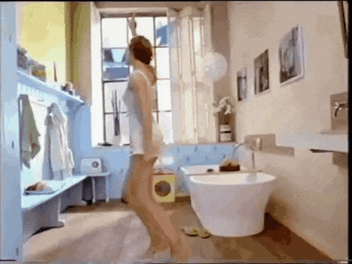 a woman is standing in a bathroom with a bathtub